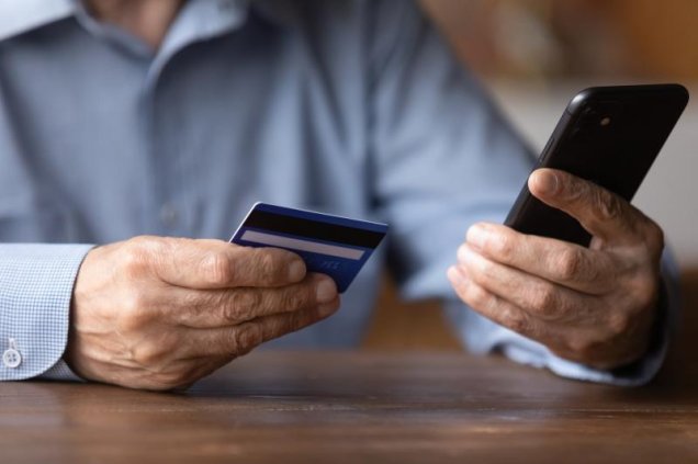 Man using debit card to make payment on phone
